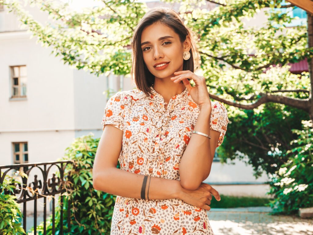 Portrait of young beautiful smiling  woman in trendy summer sundress.Sexy carefree woman posing on the street background at sunset. Positive model outdoors